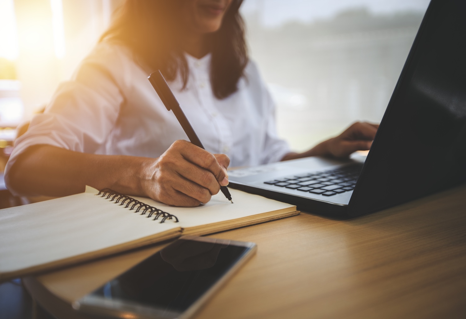 Student sitting at laptop taking notes