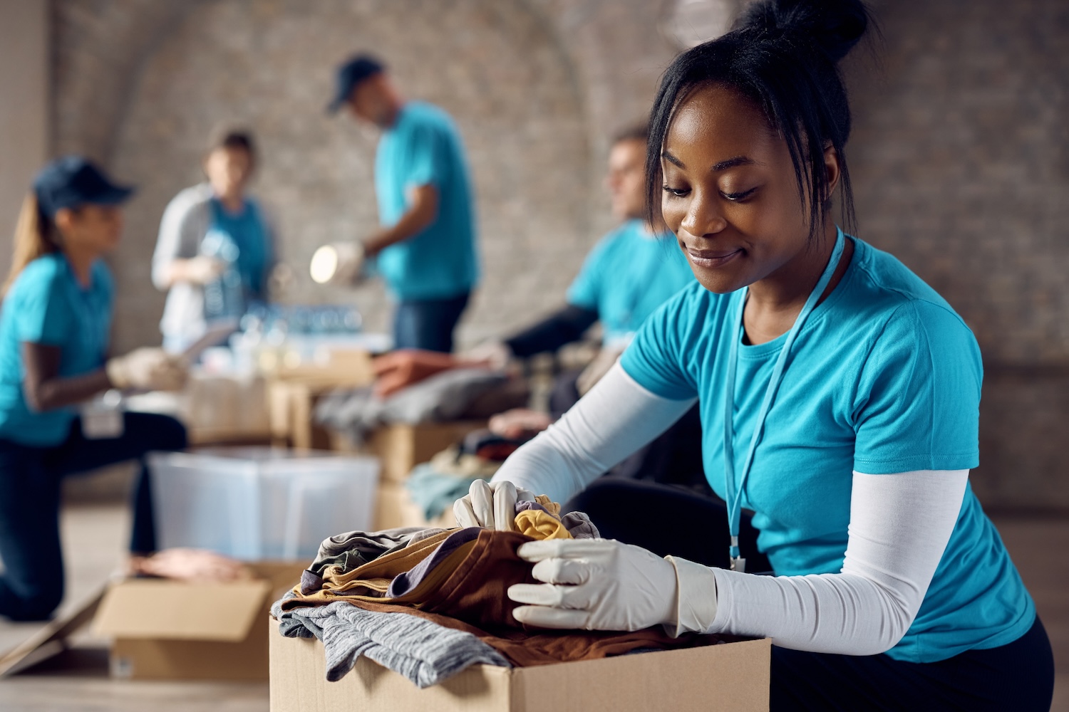 Volunteer in blue shirt packing a supply box